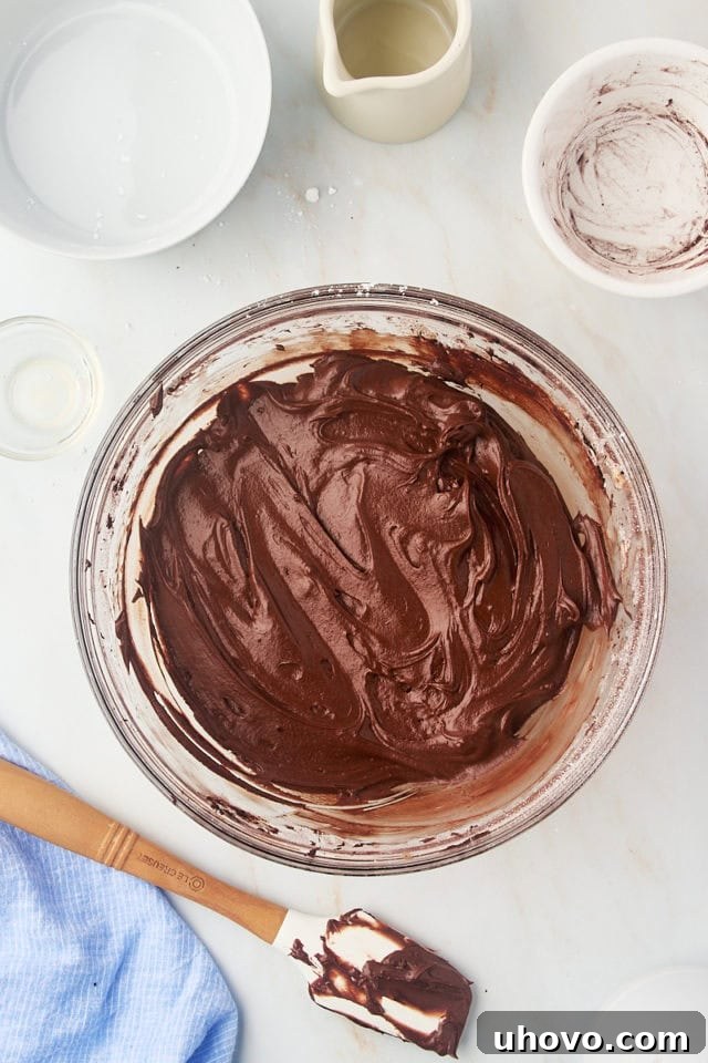 overhead view of chocolate frosting in a glass mixing bowl