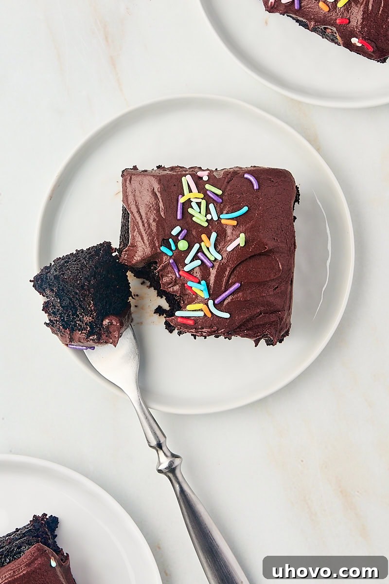 overhead view of a slice of one-bowl chocolate cake on a white plate with a bite on a fork