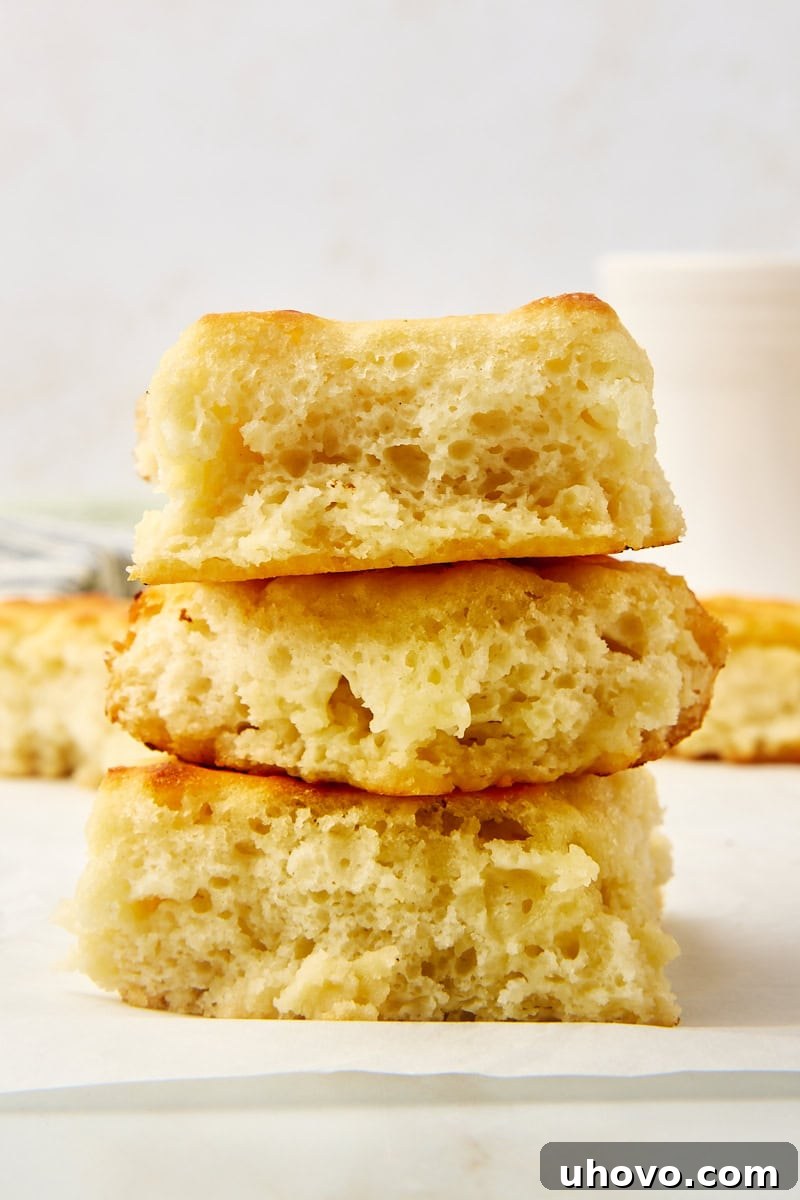 A stack of three golden-brown butter swim biscuits, showcasing their inviting texture.