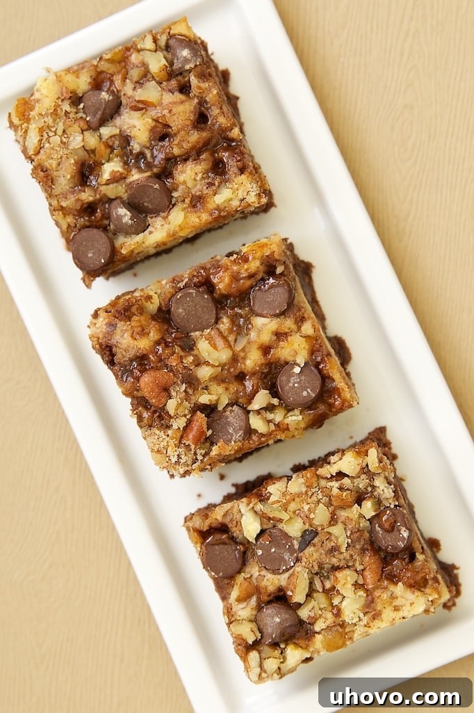 Overhead view of cream cheese brownies with toffee and pecans on rectangular tray