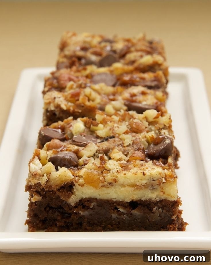 3 cream cheese brownies with toffee and pecans lined up on rectangular tray