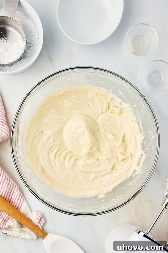 Overhead view of finished brown sugar cream cheese frosting in a glass mixing bowl, light and fluffy.