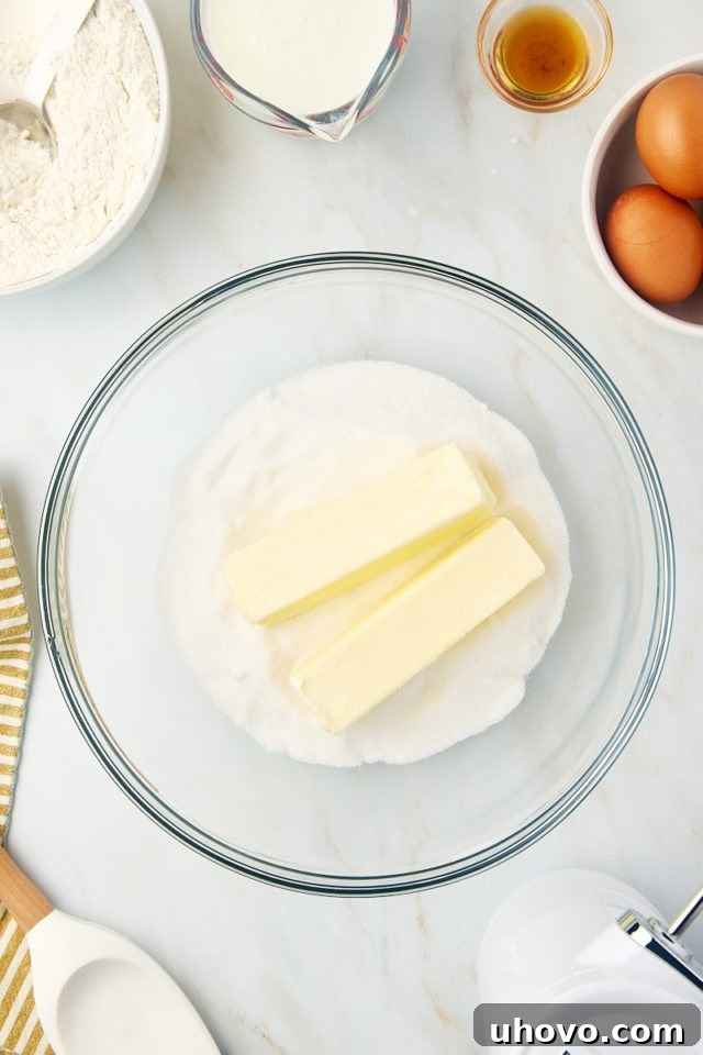 overhead view of butter and sugar in a glass mixing bowl