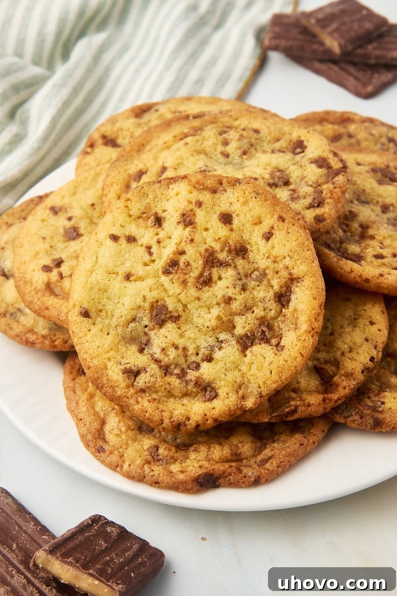 A generous pile of freshly baked Heath bar cookies on a white plate, ready to be enjoyed.