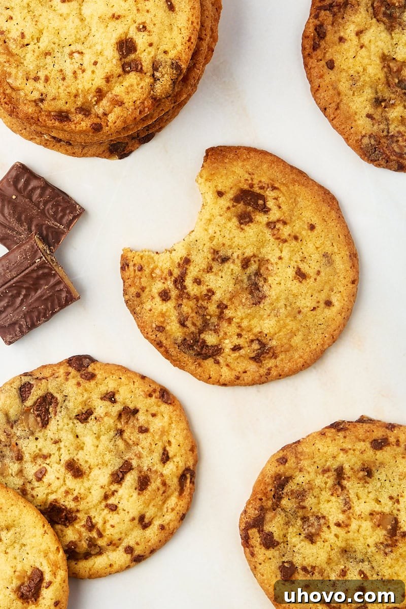 Overhead view of Heath bar cookies on countertop with one cookie having a bite taken out, revealing its soft interior and melted toffee.