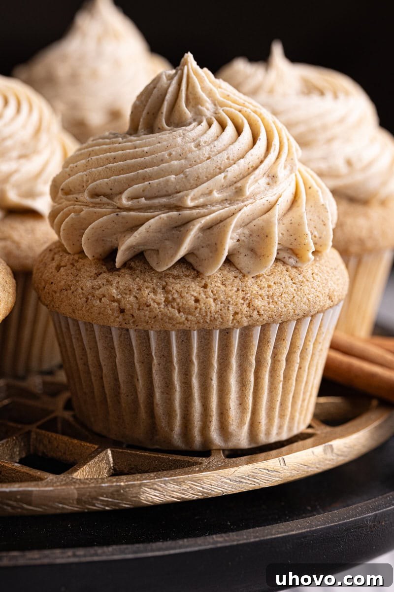 Chai spice cupcakes elegantly arranged on a black cake stand, ready to be enjoyed.