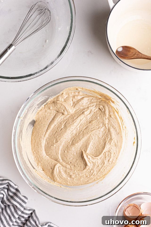 Overhead view of the smooth chai spice cupcake batter in a large glass mixing bowl.