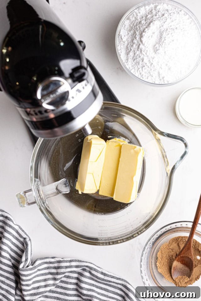 Overhead view of softened unsalted butter in the bowl of a stand mixer, ready to be beaten.