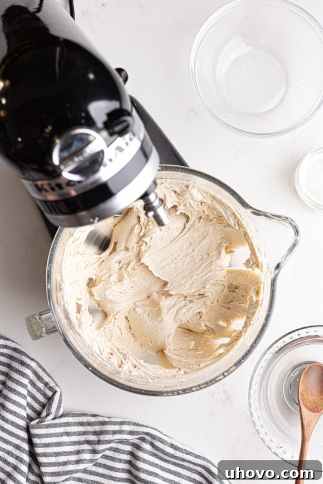 Overhead view of thoroughly mixed chai spice frosting in the bowl of a stand mixer, smooth and ready to use.