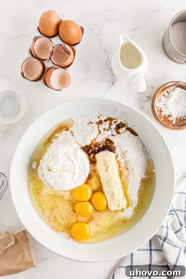 The wet ingredients for Cinnamon Roll Cake are carefully blended into the dry mixture, forming the cake base.