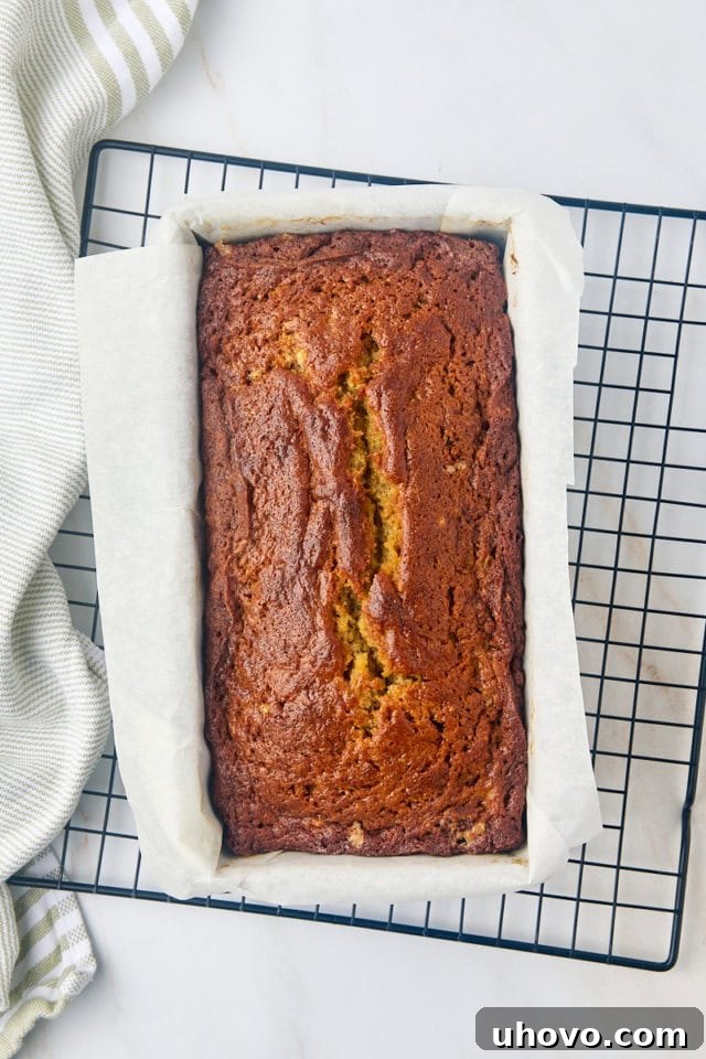 overhead view of freshly baked banana bread in a loaf pan on a wire rack