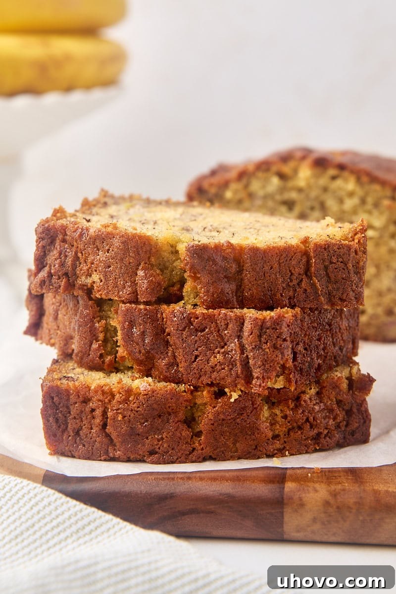 stack of three slices of banana bread with more bread in the background