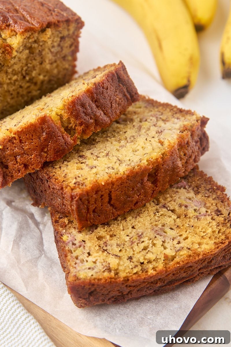 three slices of banana bread fanned out on a wooden cutting board