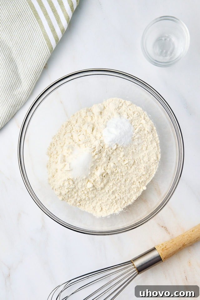 overhead view of flour, baking soda, and salt in a glass mixing bowl