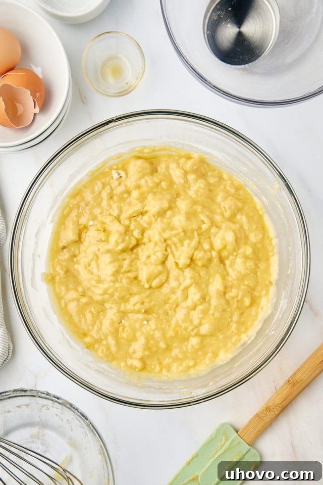overhead view of mixed banana bread batter in a glass mixing bowl