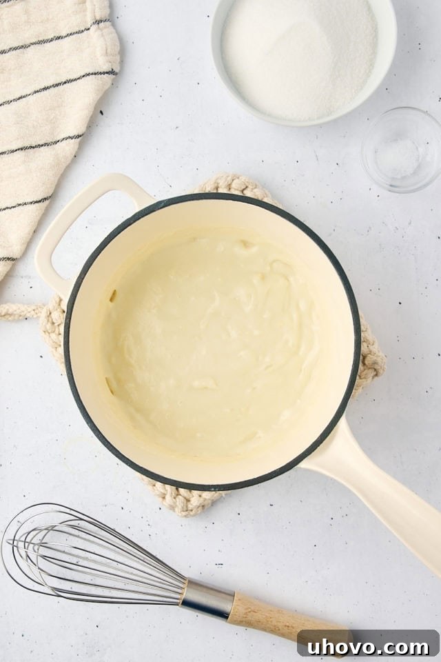 Overhead view of the milk and flour mixture in a saucepan, thickened to a pudding-like consistency for the ermine frosting.