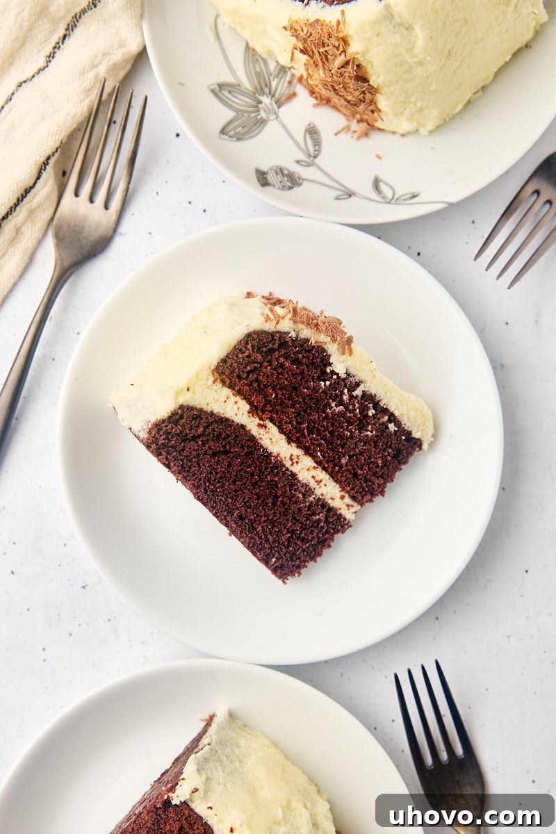 Overhead view of a beautifully frosted mahogany cake with clean slices on white plates, ready for serving.