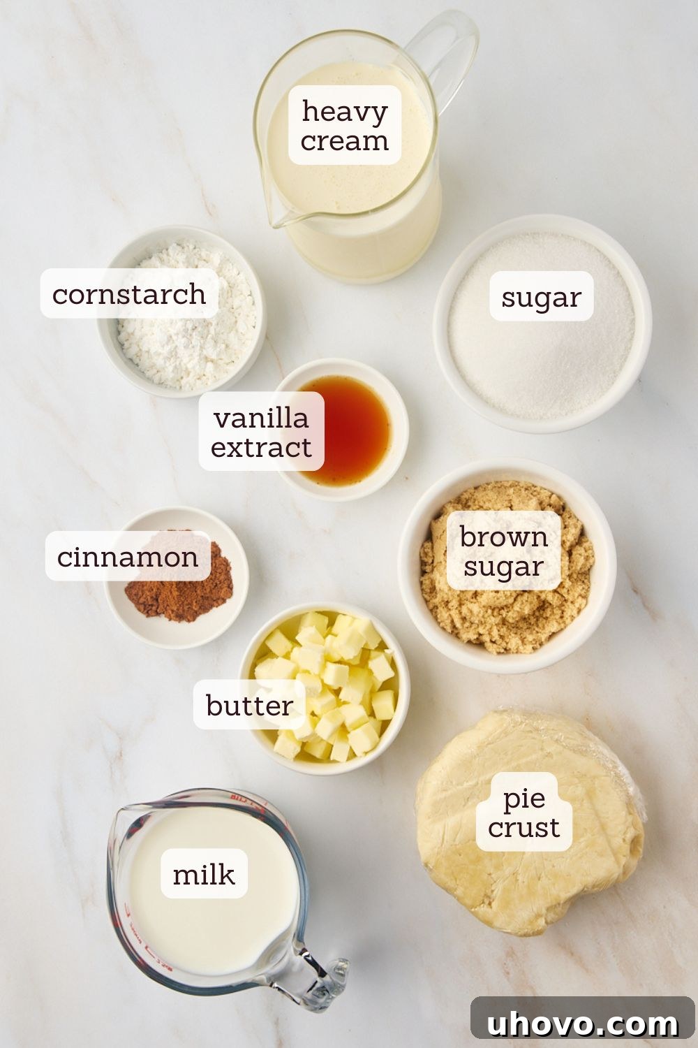 An overhead view of the simple, essential ingredients for a classic sugar cream pie laid out on a clean kitchen surface.