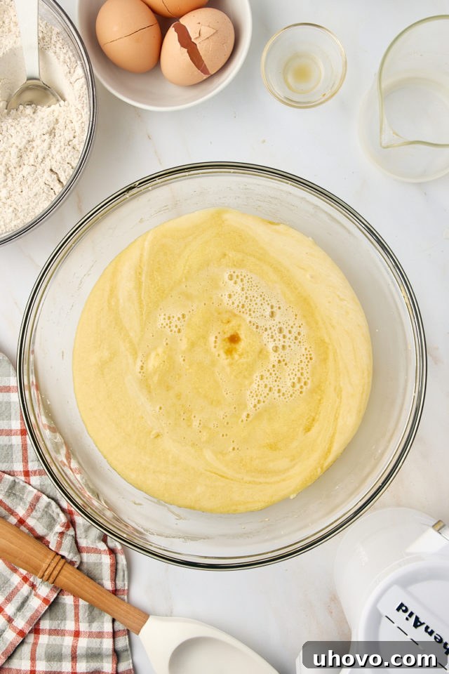 overhead view of apple cider added to cake batter
