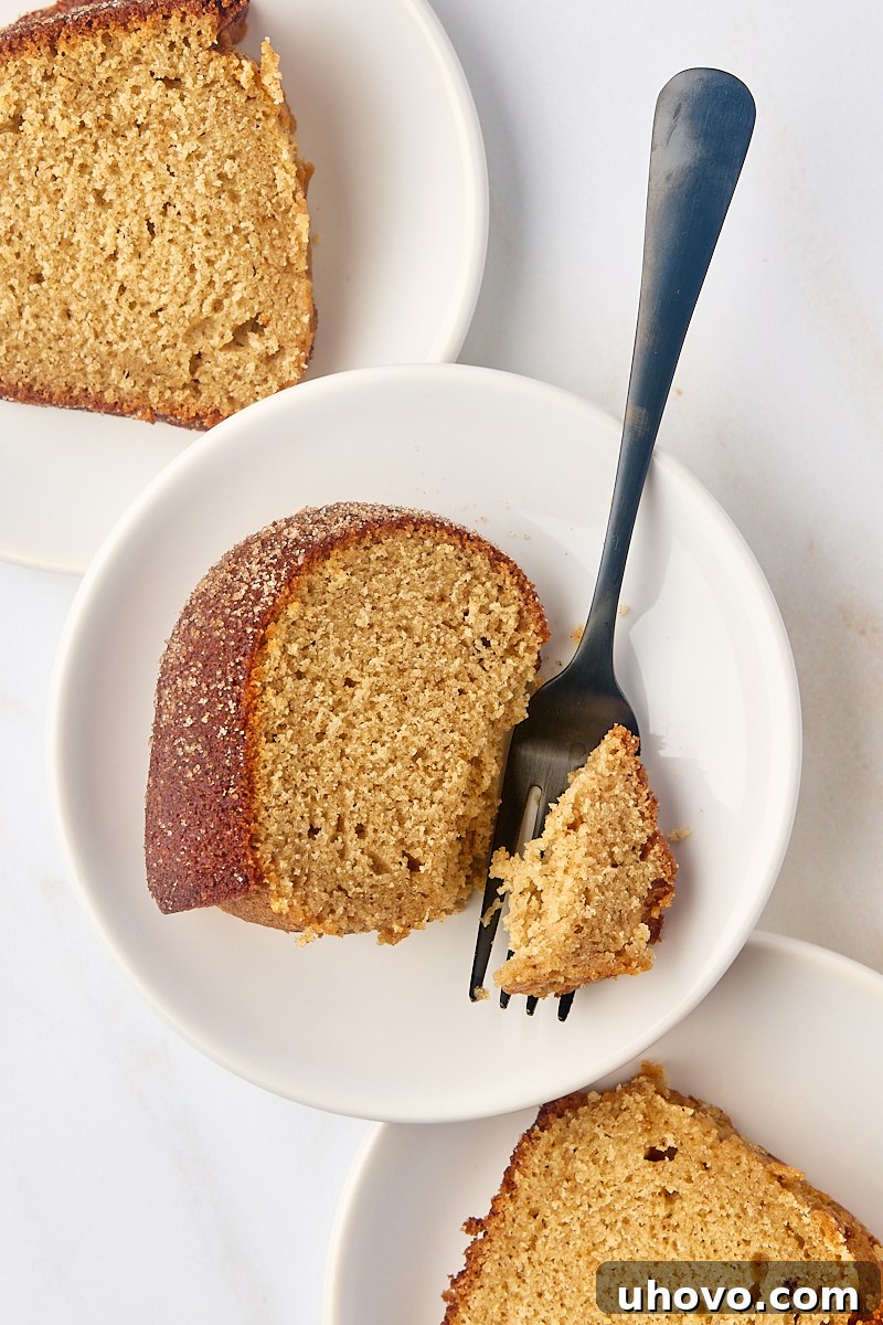 overhead view of three slices of apple cider donut cake on white plates