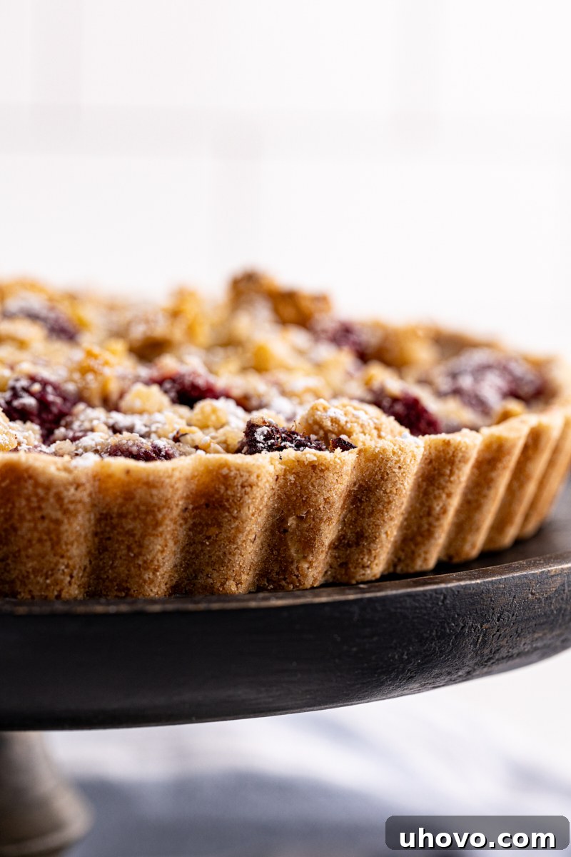 Side view of raspberry crumb tart to show almond crust
