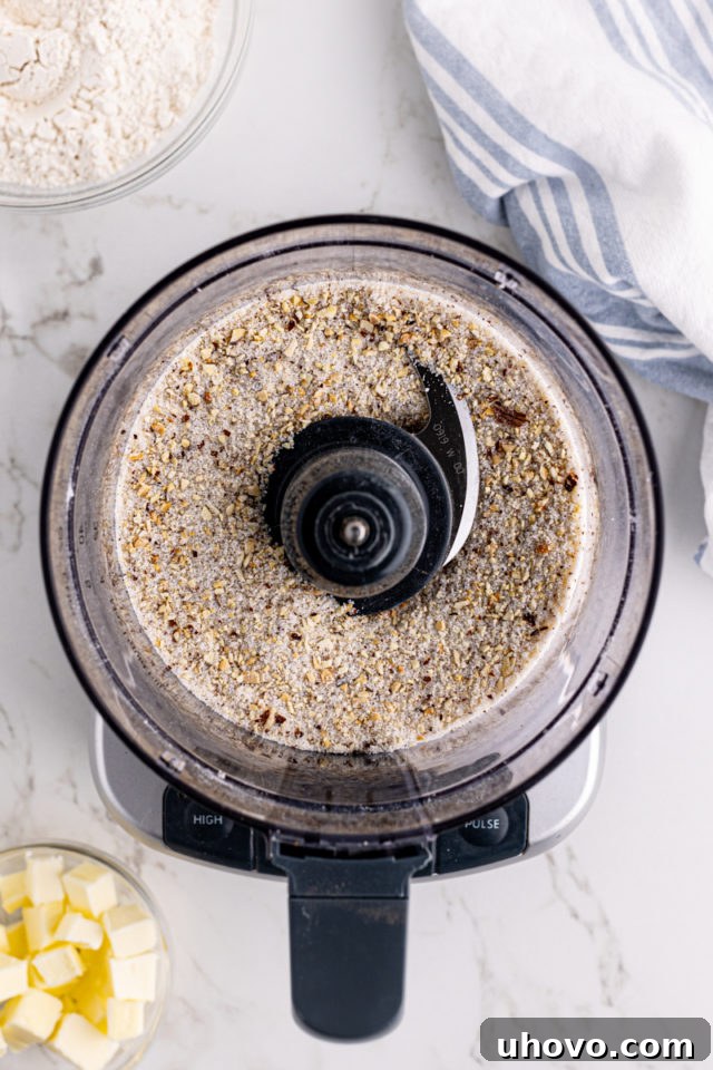 Overhead view of ground almonds and sugar in food processor