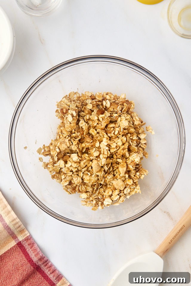 A close-up, overhead view of the thoroughly mixed oat filling for the baked pears, showcasing its crumbly, cohesive texture ready for stuffing.