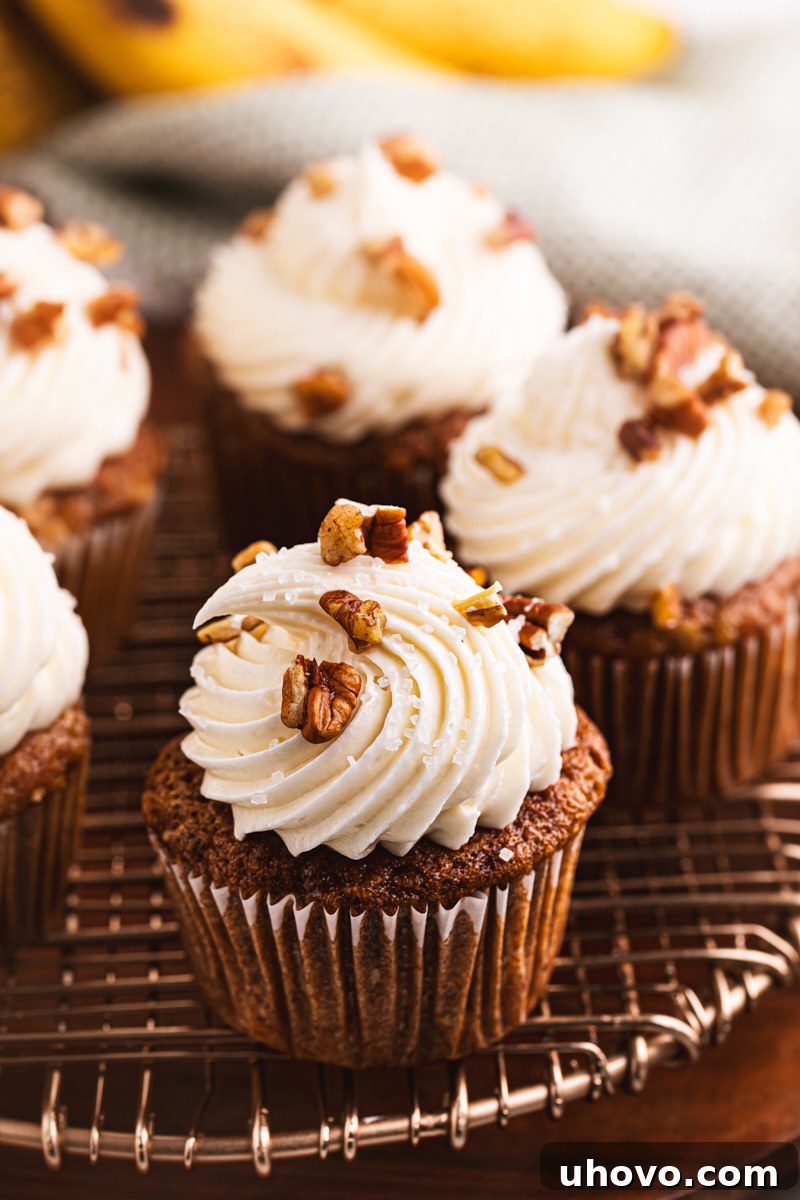 A dozen freshly baked Hummingbird Cupcakes cooling on a wire rack, ready for frosting.
