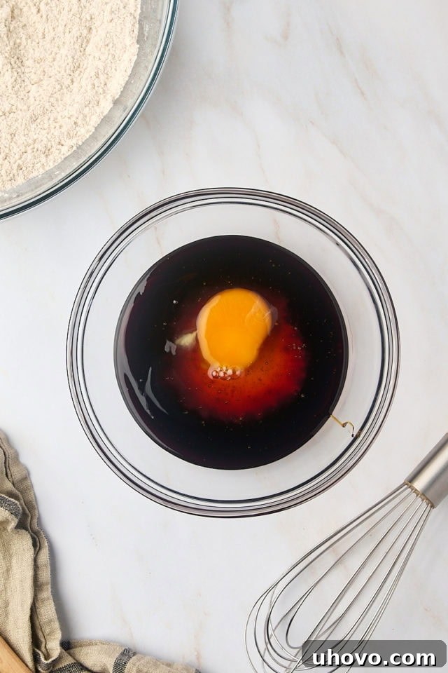 overhead view of molasses, honey, and egg in a mixing bowl