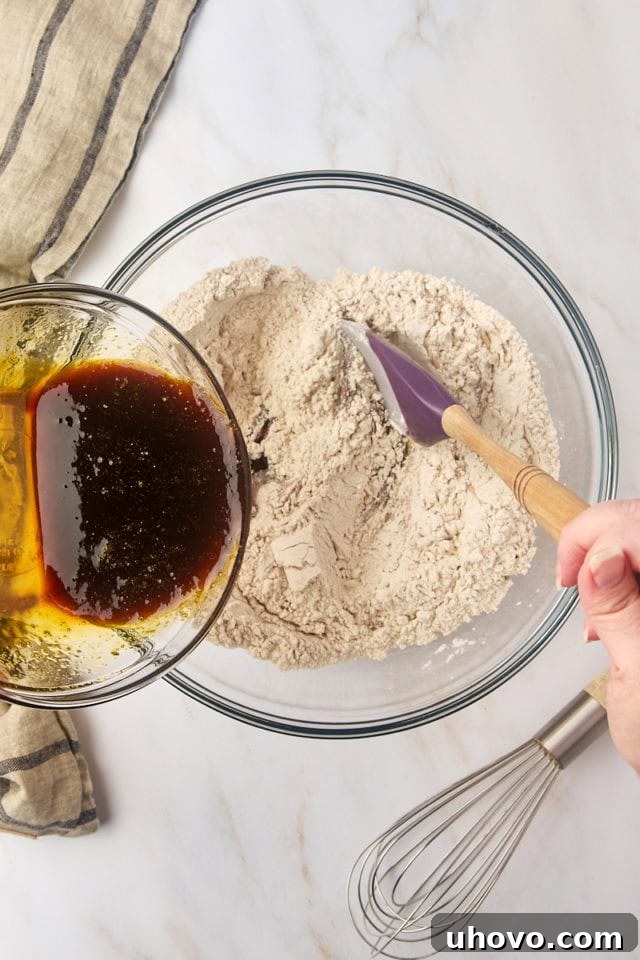 overhead view of wet ingredients being added to dry ingredients for Pfeffernüsse cookies