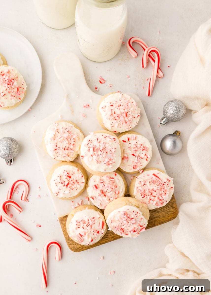 Overhead view of frosted peppermint meltaways adorned with crushed candy canes, elegantly arranged on a marble and wood serving board.