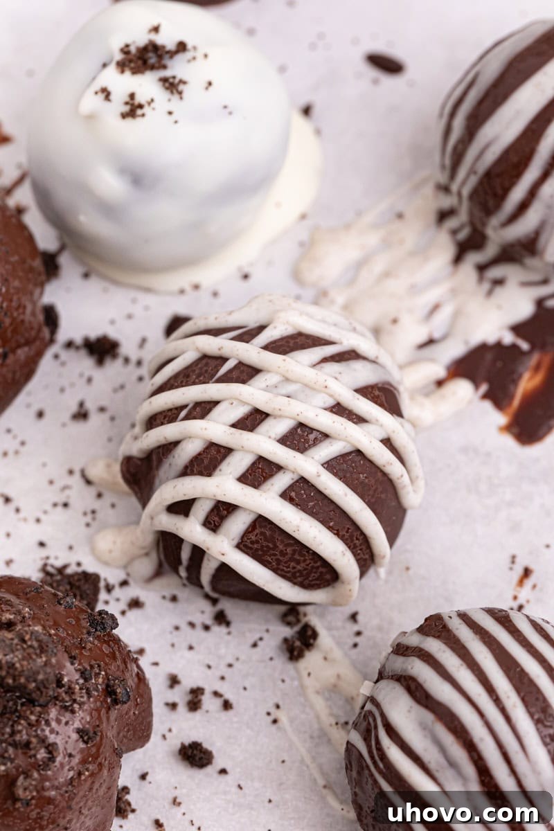 A variety of finished Oreo truffles with different toppings and chocolate coatings, including dark chocolate, white chocolate, sprinkles, and crushed Oreos.