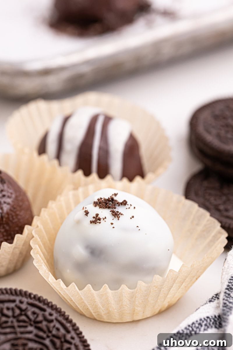 Oreo truffles neatly placed in mini white muffin liners on a serving platter, showcasing their appealing presentation.