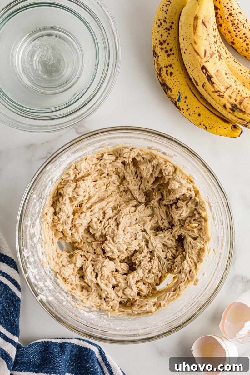 Overhead view of banana oatmeal crumb cake batter in glass bowl