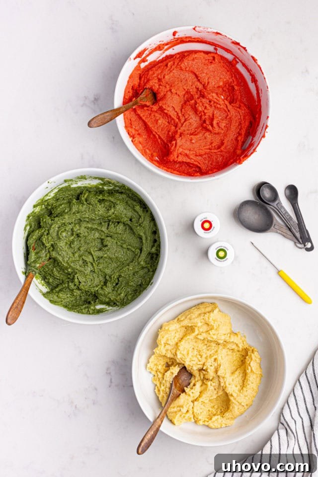 Overhead view of three portions of Italian rainbow cookie dough—one plain, one tinted green, and one tinted red.