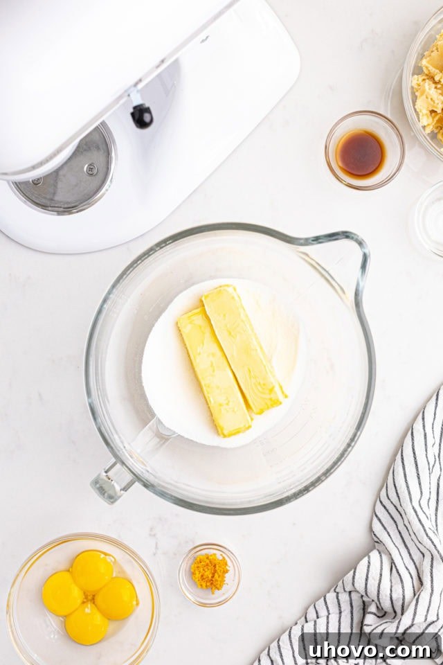 Overhead view of softened butter and granulated sugar in the bowl of a stand mixer, creaming together.