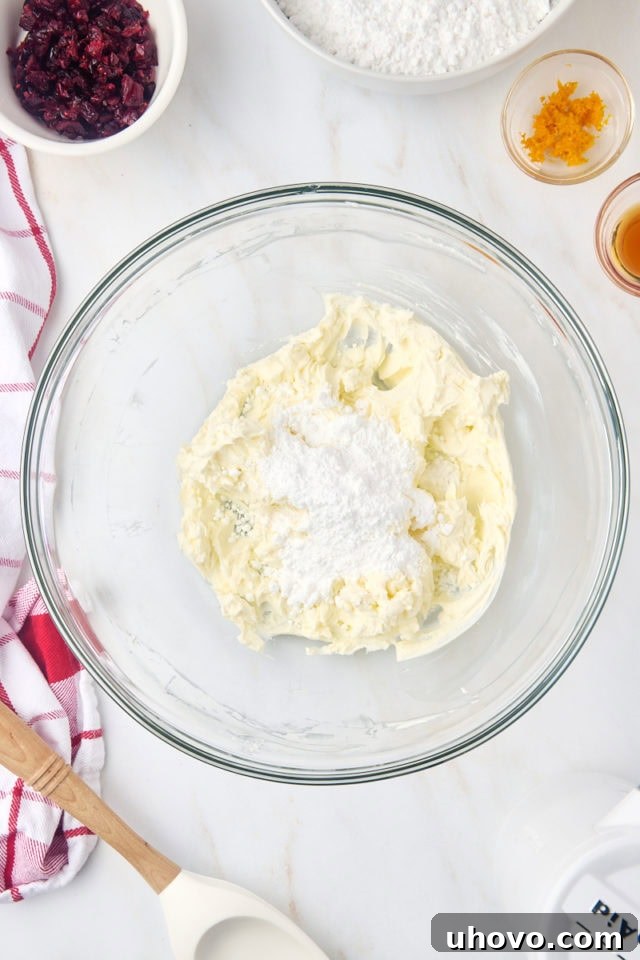 Overhead view of confectioners' sugar added to beaten cream cheese