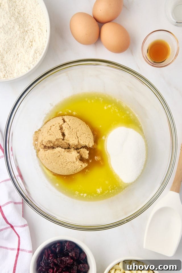 Overhead view of melted butter, brown sugar, and sugar in a mixing bowl