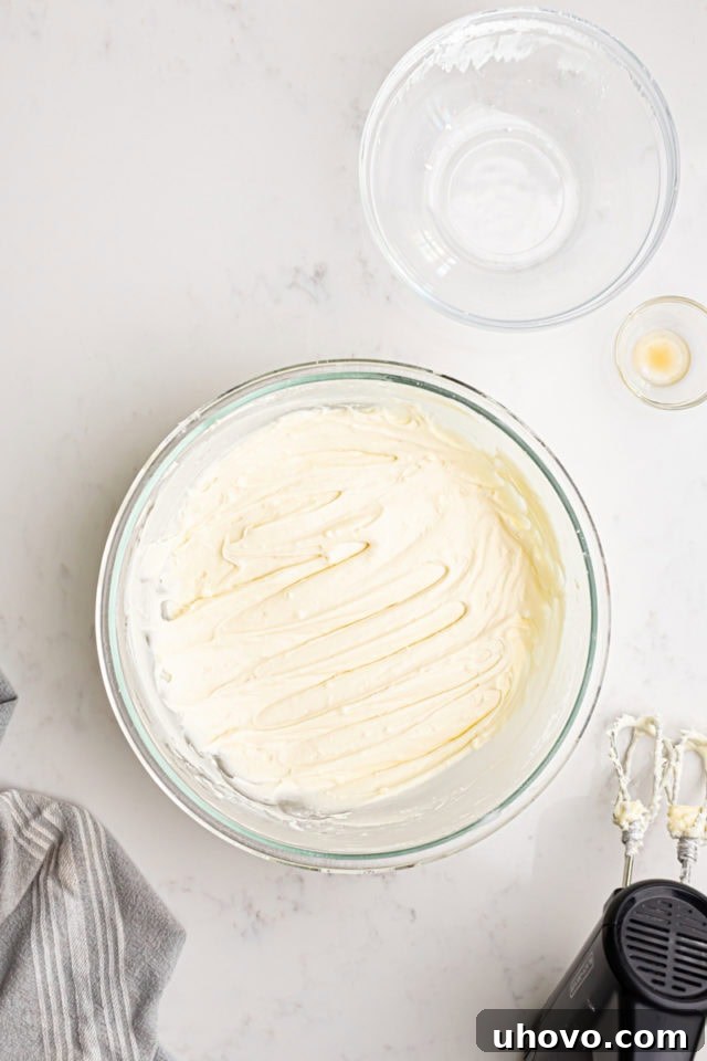 A bowl of freshly made, smooth, and creamy cream cheese frosting, ready to be spread on the cake.