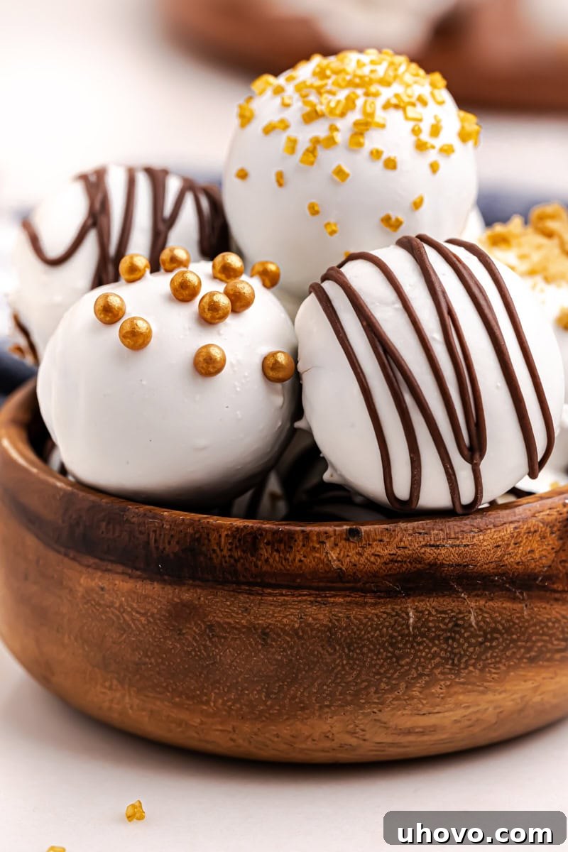 A close-up view of beautifully decorated gingerbread truffles in a wooden bowl, showcasing their creamy texture and festive garnishes.