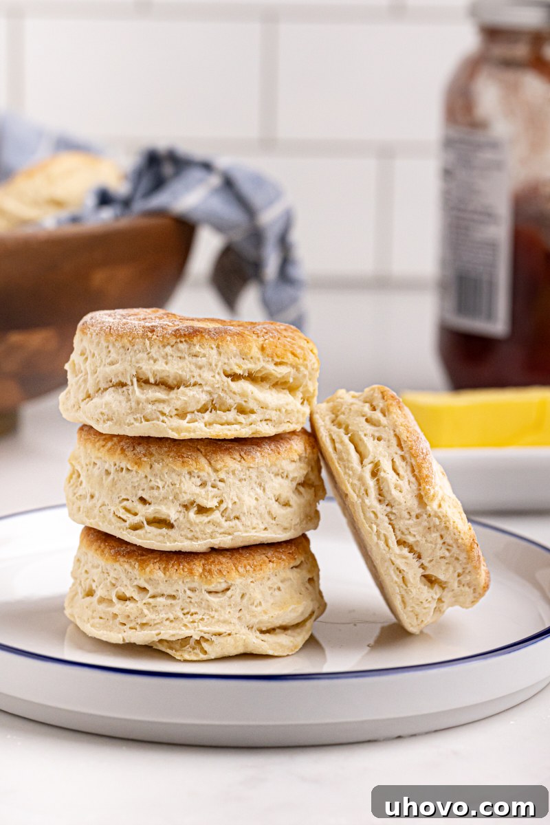 Stack of homemade buttermilk biscuits on plate, golden brown and flaky
