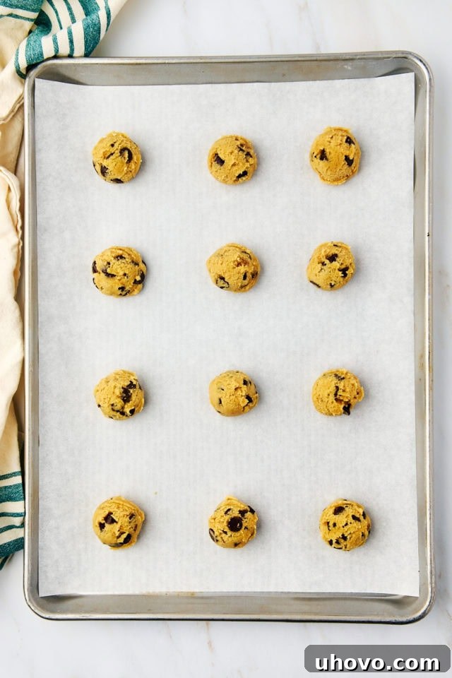 overhead view of scooped tahini chocolate chip cookie dough on a baking sheet ready to go into the oven