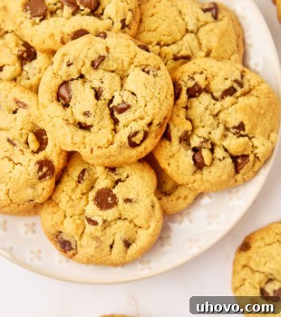 tahini chocolate chip cookies on a white plate surrounded by more cookies