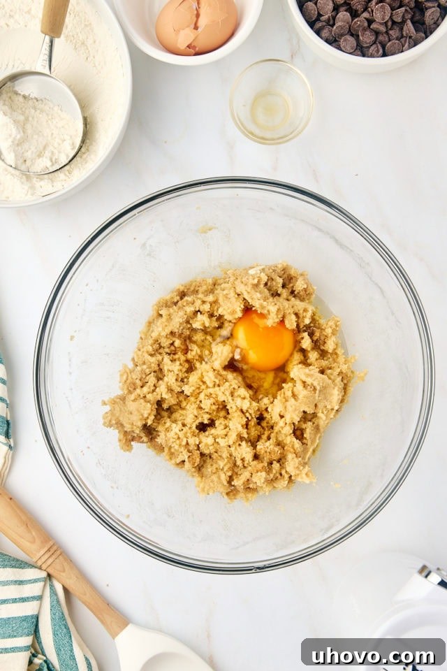 overhead view of egg added to creamed butter and sugar
