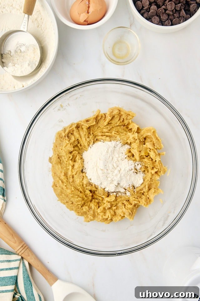 overhead view of dry ingredients added to wet ingredients for tahini chocolate chip cookies