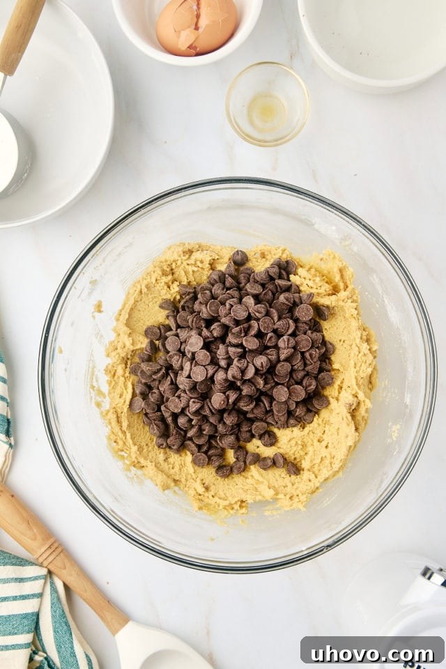 overhead view of chocolate chips added to cookie dough