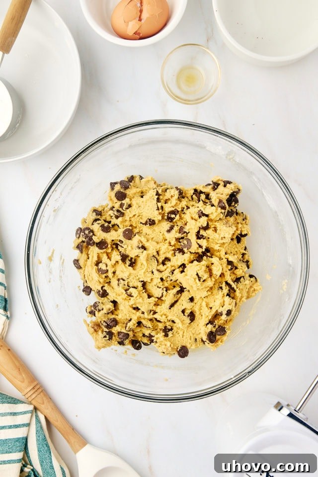 overhead view of tahini chocolate chip cookie dough in a glass mixing bowl