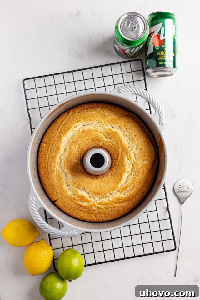 Overhead view of a freshly baked 7UP cake still in its tube pan, resting on a wire rack.