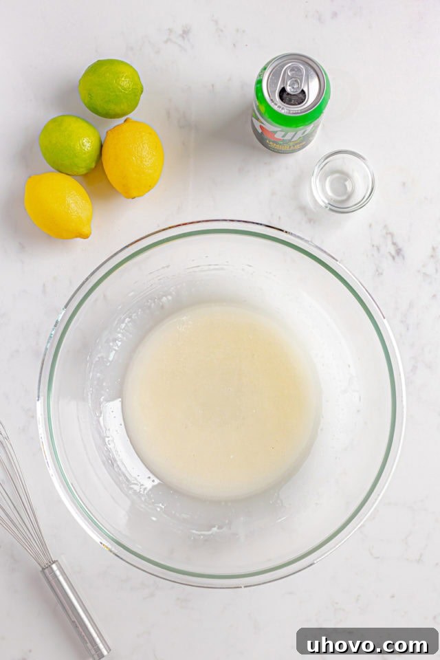 Overhead view of the smooth, pourable glaze for 7UP cake in a clear glass bowl, ready to be drizzled.