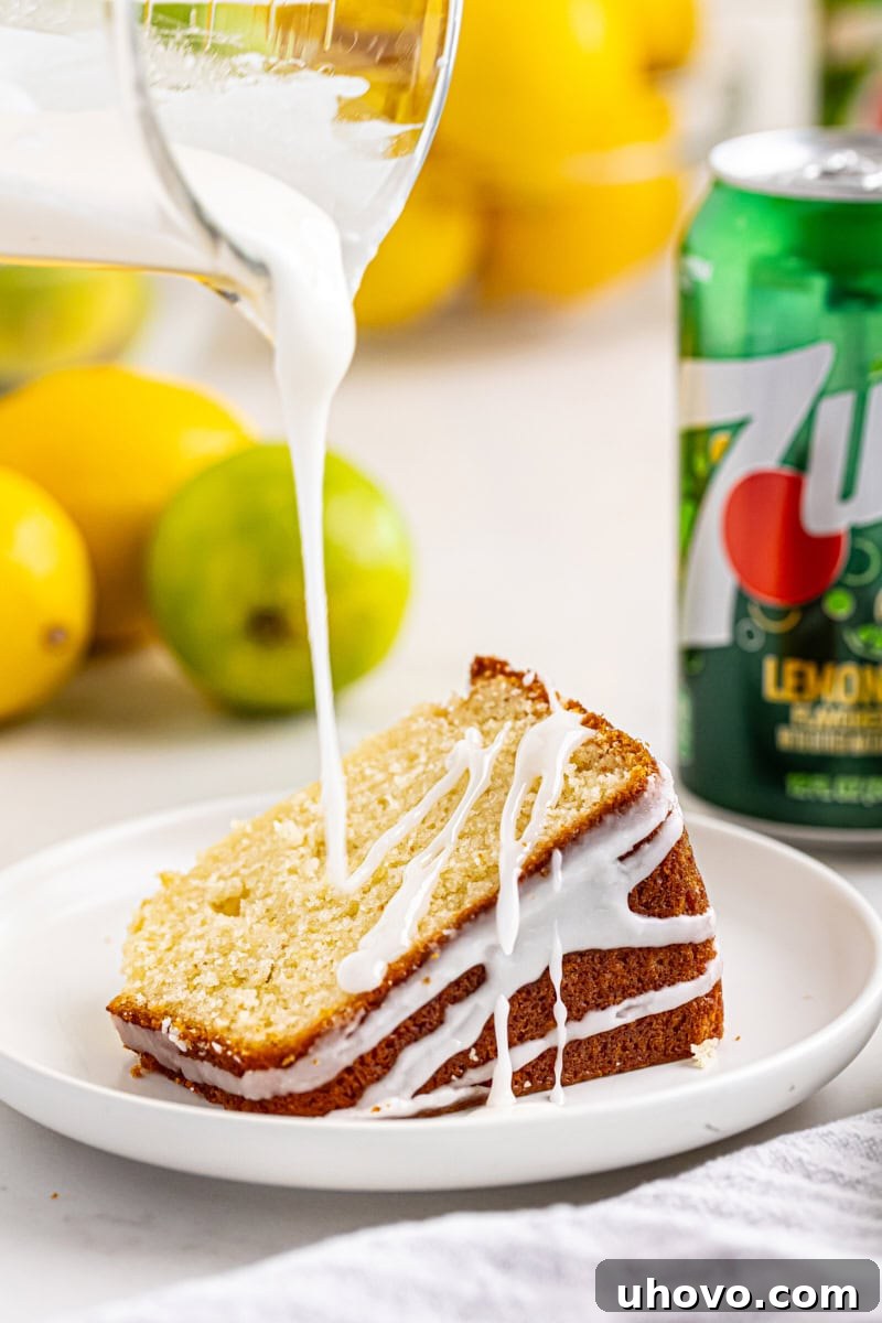 Close-up of a tangy glaze being drizzled artfully over a fresh slice of 7UP cake, highlighting its moist interior.